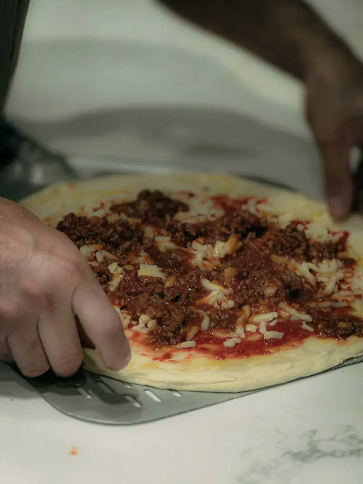 A pizza being prepared at 67 Sourdough in East Finchley